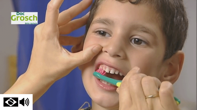 Adulto ensinando a escovar os dentes de uma criança corretamente