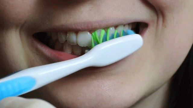 Escova posicionada em ângulo contra os dentes